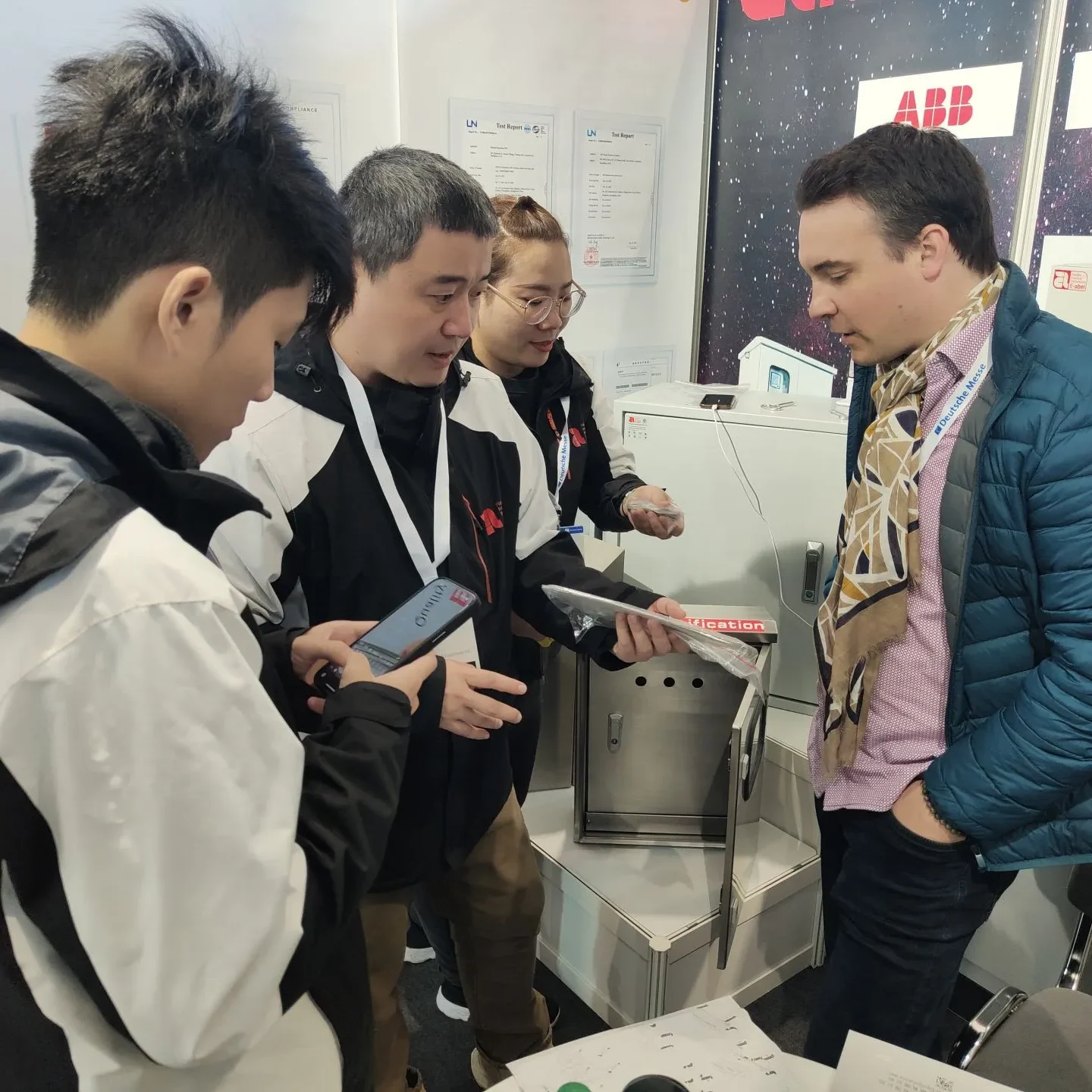 Eabel team engaging with a customer at the German exhibition to understand their electrical enclosure needs - Assembly Service - E-Abel - E-Abel - Assembly Service - E-Abel - E-Abel L'équipe Eabel s'entretient avec un client lors du salon allemand pour comprendre ses besoins en matière de boîtiers électriques