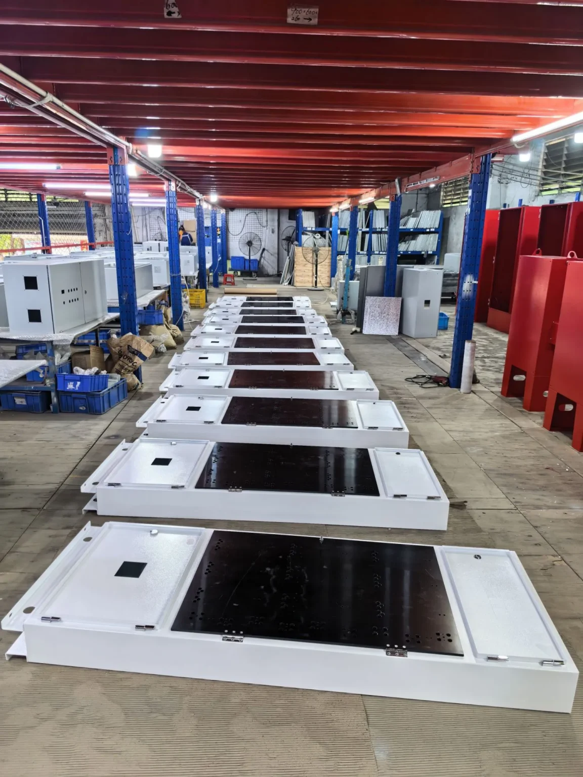 White cabinet panels arranged in factory workshop - Floor-Standing Switchgear Enclosures for Heavy-Duty Power Distribution - E-Abel - E-Abel - Knowledge Hub - E-Abel - E-Abel Panneaux d'armoires blancs disposés dans l'atelier de l'usine